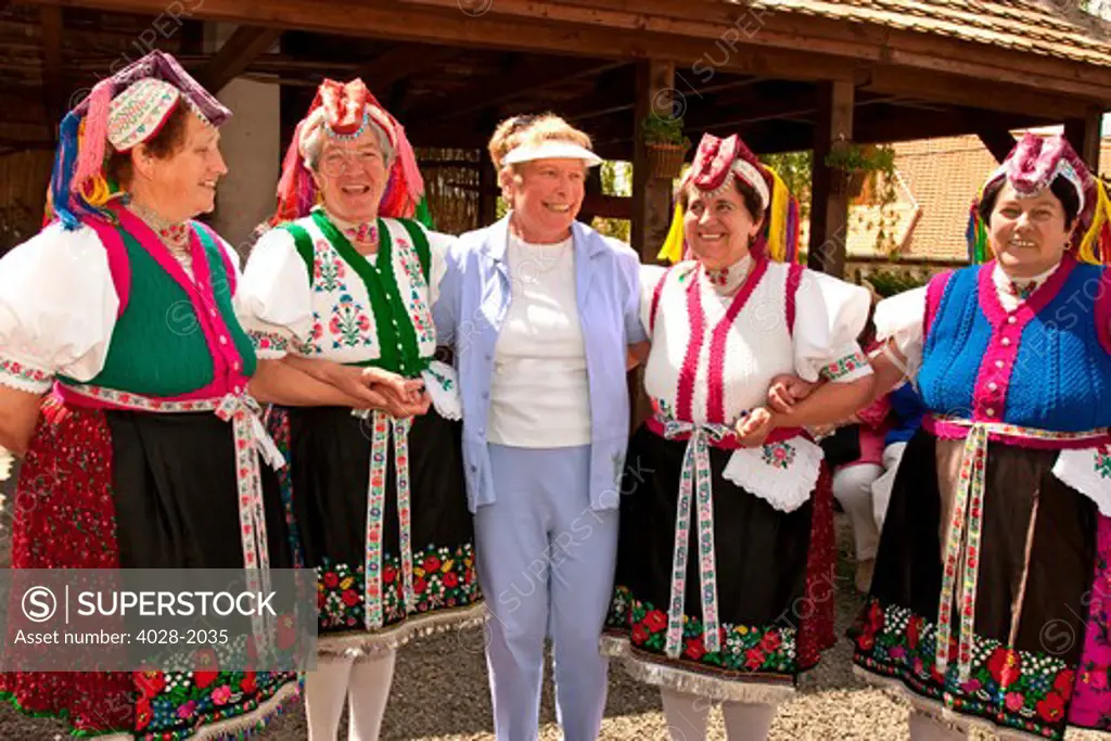 Woman Dressed in Traditional Clothing, Holloko, Hungary stand with a tourist