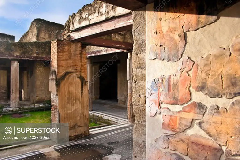 Casa dei Cerv (House of the Deer), ruins of the old Roman city of Herculaneum near Naples, Italy. Remains of an ancient fresco adorns the near wall.