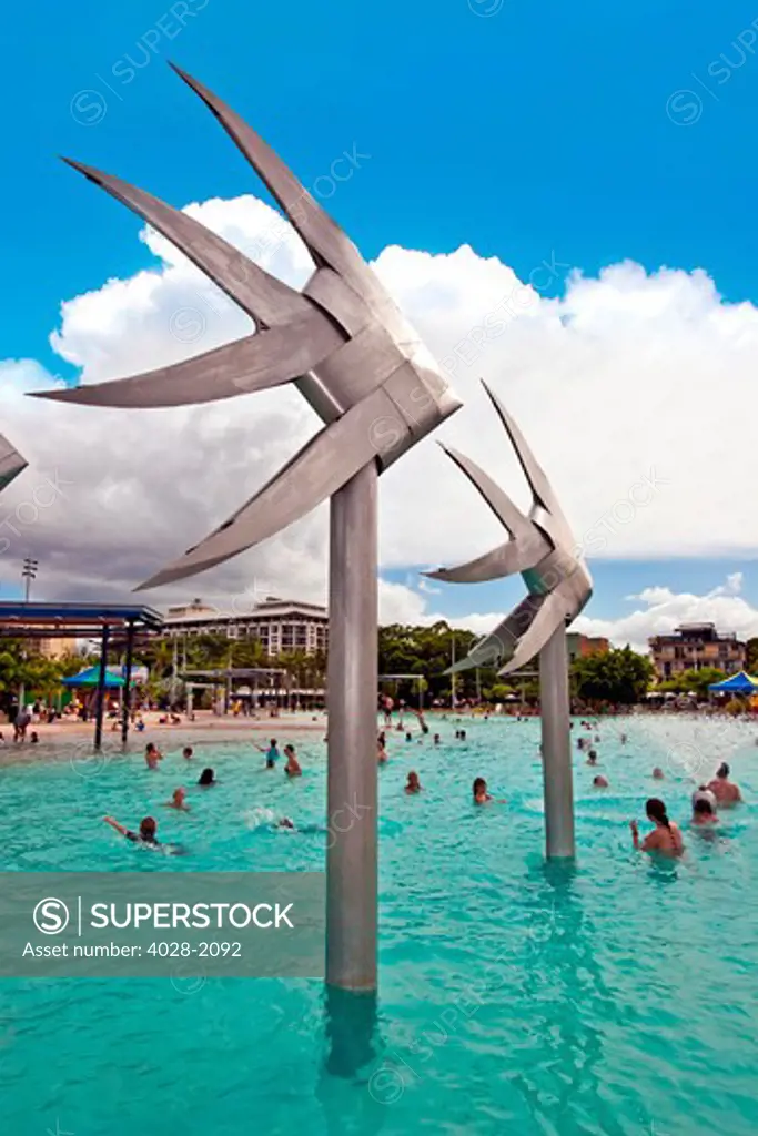 People swimming by the fish sculpture at Esplanade lagoon, Cairns, Queensland, Australia
