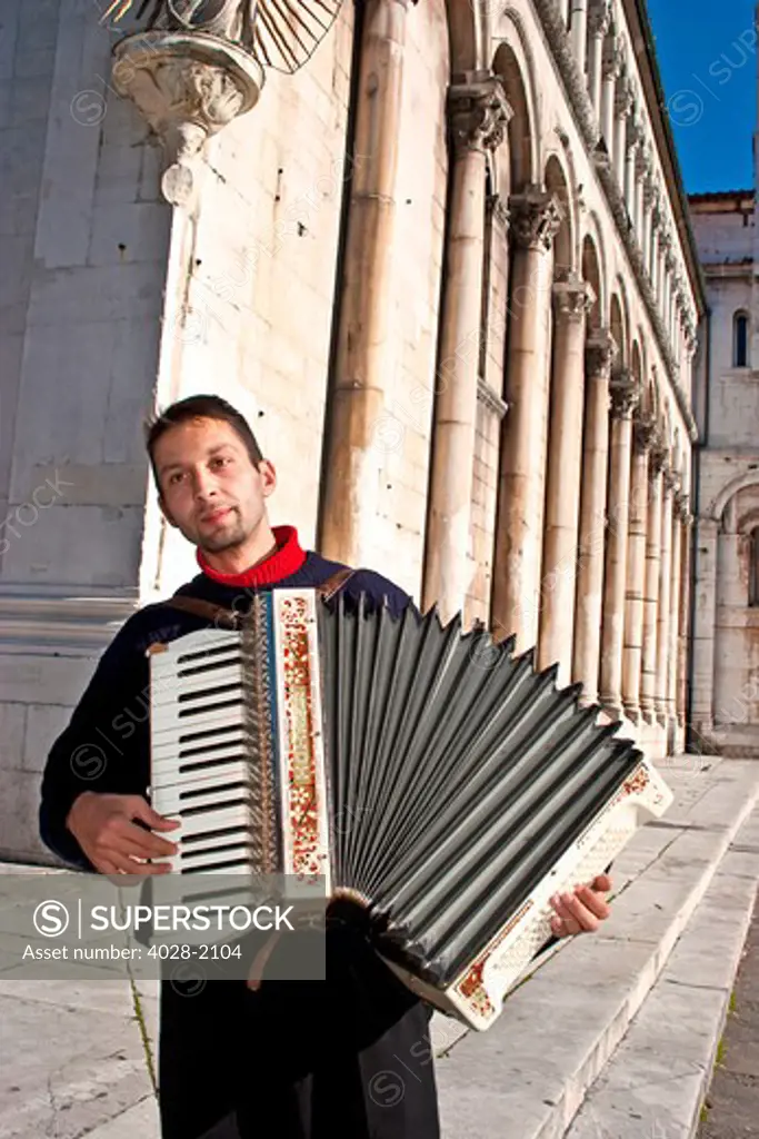 An accordian player in the ancient streets of Lucca, Tuscany, Italy, Europe