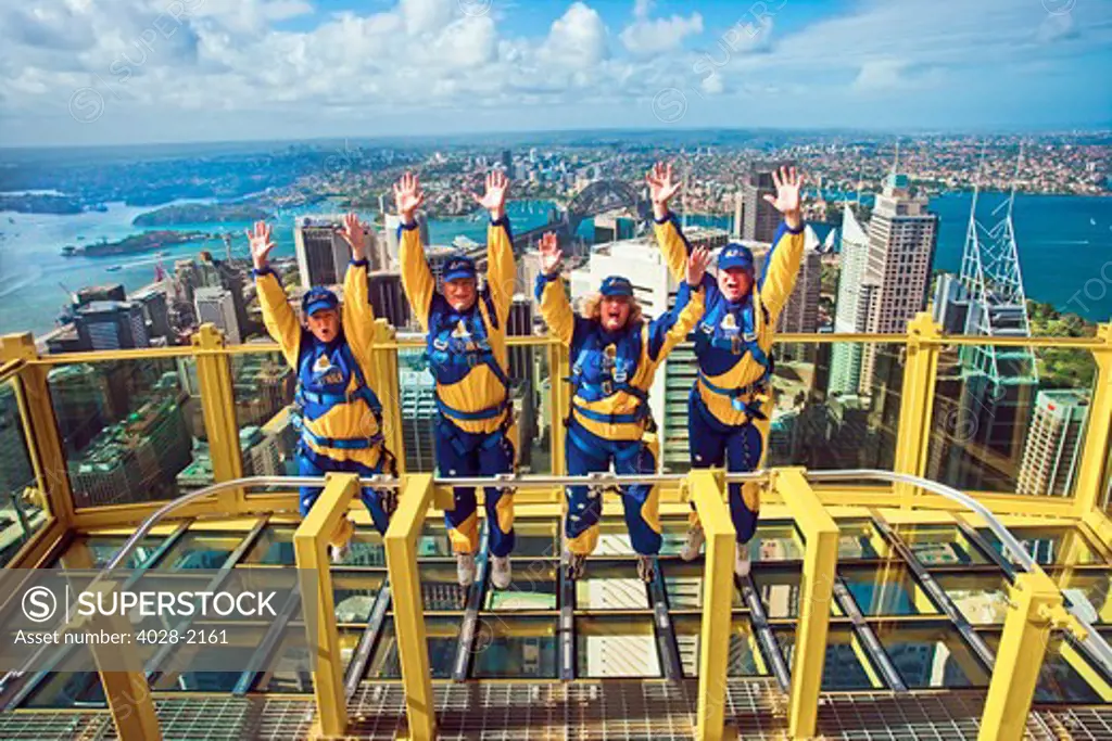 Australia, Sydney, New South Wales, tourists jump of joy from outside of the Sydney tower on the Skywalk