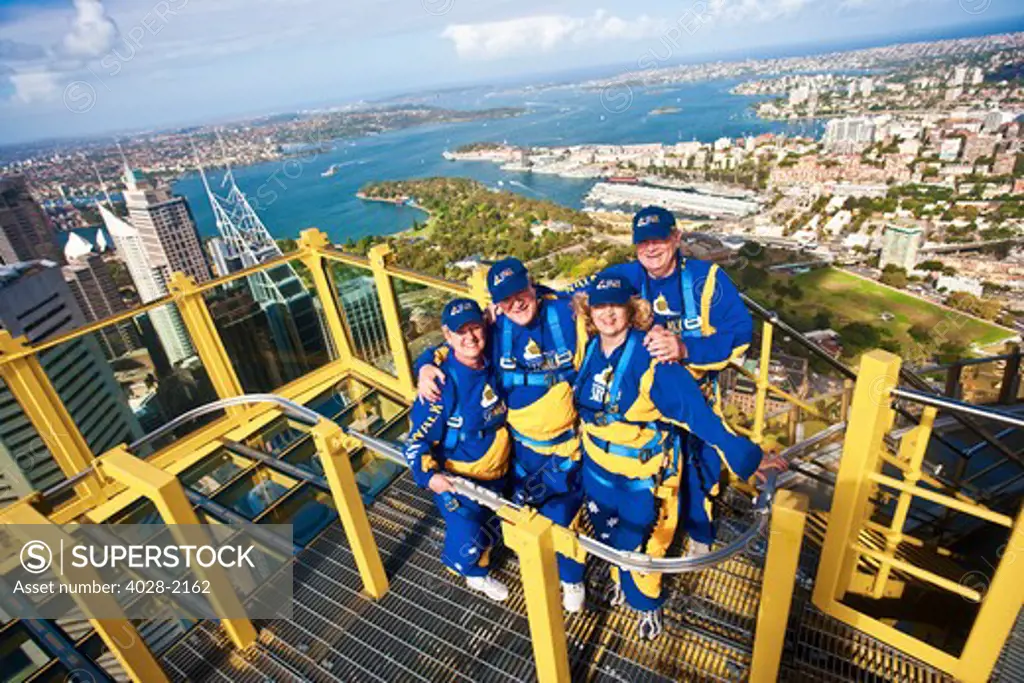Australia, Sydney, New South Wales, tourists pose on a platform outside of the Sydney tower on the Skywalk