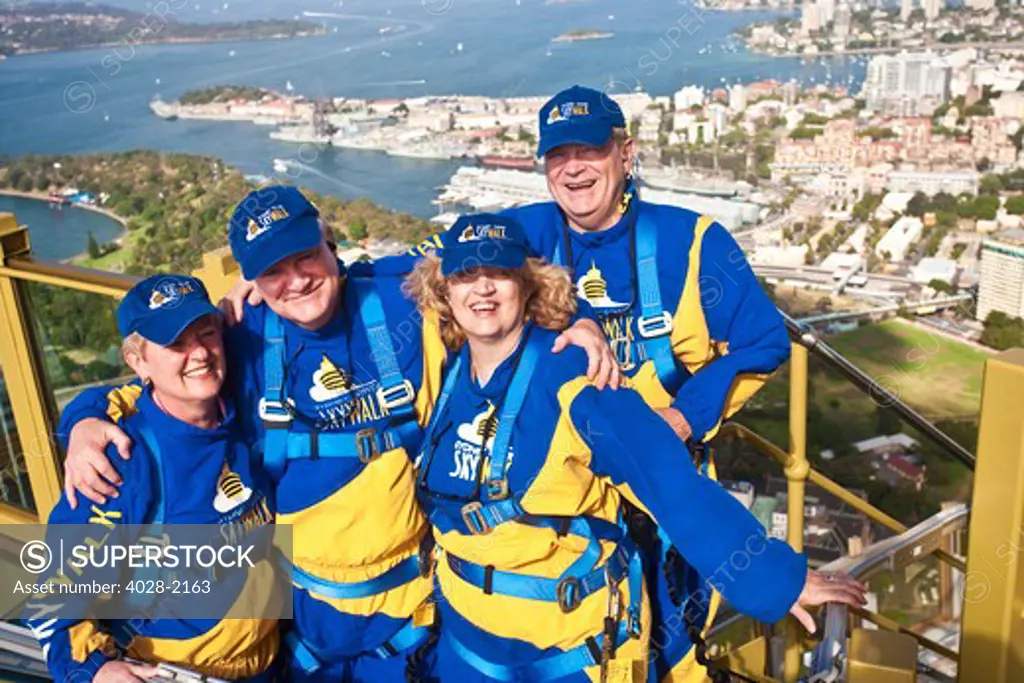 Australia, Sydney, New South Wales, tourists pose on a platform outside of the Sydney tower on the Skywalk
