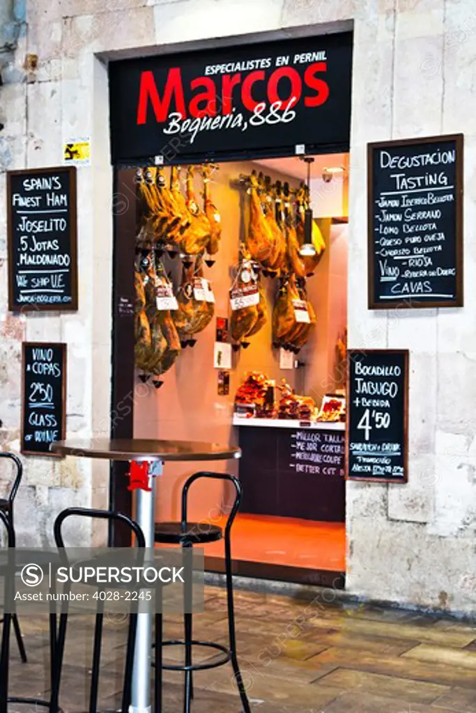 Barcelona, Catalonia, Spain, La Boqueria, La Rambla, inside the marktet vendors display and sell traditional jambon (ham) in their store