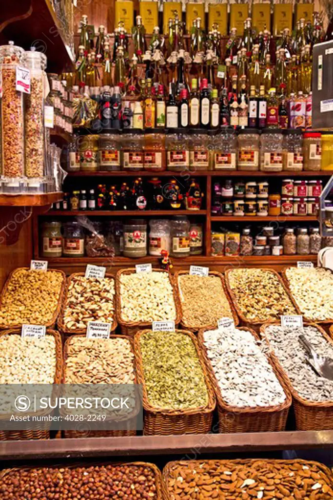 Barcelona, Catalonia, Spain, La Boqueria, La Rambla, vendors display and sell dried fruits, nuts and oils in their market stall.