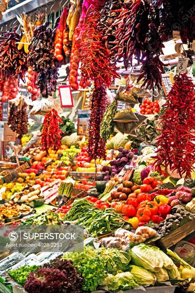 Barcelona, Catalonia, Spain, La Boqueria, La Rambla, vendors display and sell chili peppers, fruits and vegetables in their stall.