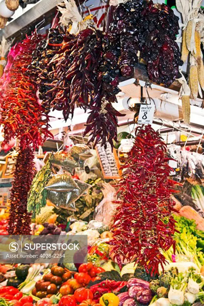 Barcelona, Catalonia, Spain, La Boqueria, La Rambla, vendors display and sell chili peppers, fruits and vegetables in their stall.