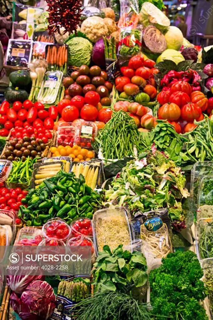 Barcelona, Catalonia, Spain, La Boqueria, La Rambla, vendors display and sell fruits and vegetables in their stall.