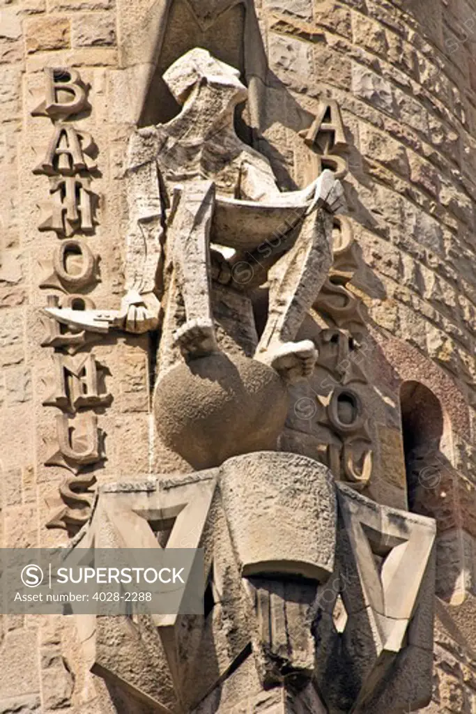 Barcelona, Catalonia, Spain, statues and stonework of  the Passion Facade of  the Temple of Sagrada Familia, by architect Josep Maria Subirachs. Bartholomew the Apostle with a knife on his tower.
