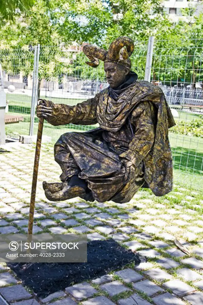Barcelona, Catalonia, Spain, Street performer defies gravity on Las Ramblas as a golden wizard
