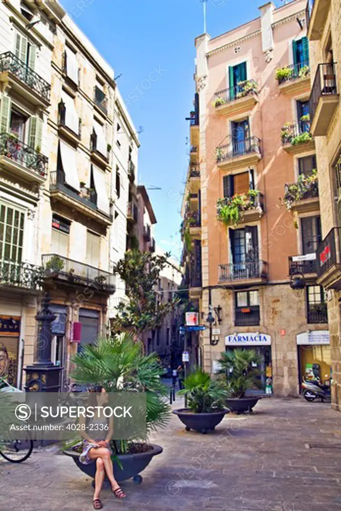 Barcelona, Catalonia, Spain, a woman admires the plazas and narrow alleyways with ornate balconies that create the atmosphere of the Gothic Quarter.
