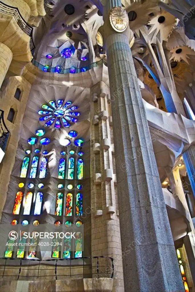 Barcelona, Catalonia, Spain, ornate stained glass window, column and ceiling of the Interior of Sagrada Familia