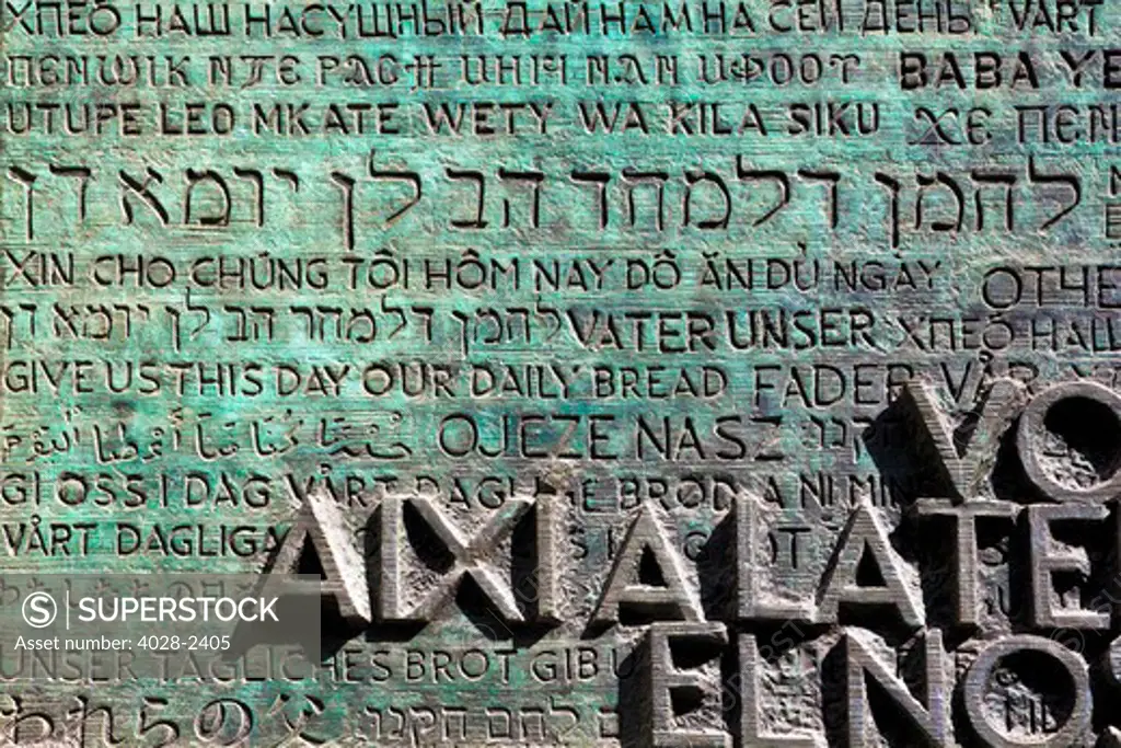 Barcelona, Catalonia, Spain, detail the entrance portico to the Glory Facade of  the Temple of Sagrada Familia, by architect Josep Maria Subirachs. The Eucarist written in 150 languages. English shown.