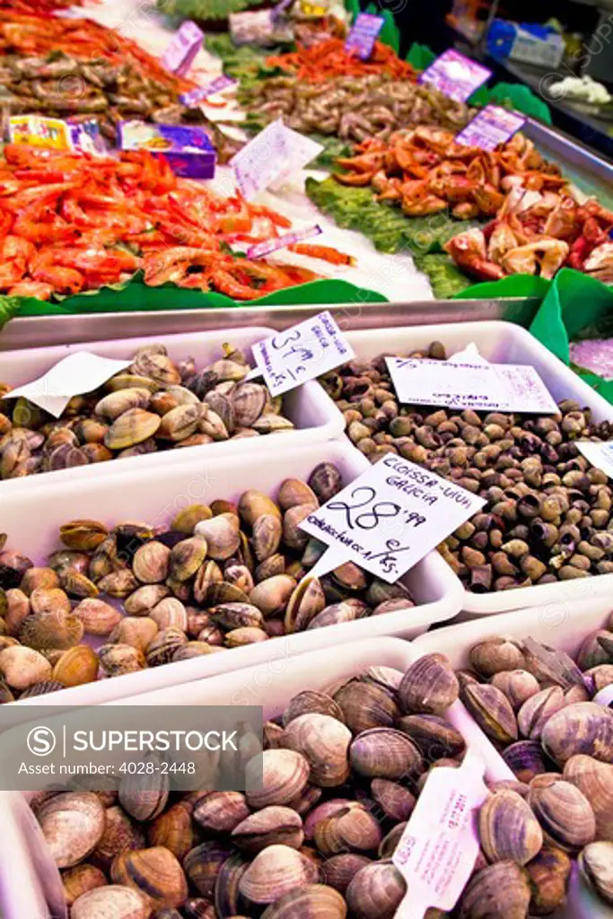 Barcelona, Catalonia, Spain, La Boqueria, La Rambla, vendors display and sell seafood, shrimp and clams in their market stall.