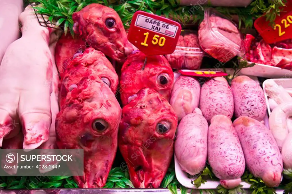 Barcelona, Catalonia, Spain, La Boqueria, La Rambla, vendors display and sell meat, heads, brains, intestine, feet and testicals in their stall.