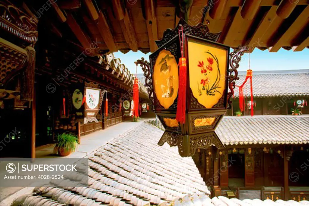 China, Beijing, Traditional Chinese gas lantern hangs above the courtyard of an historic hutong or home.