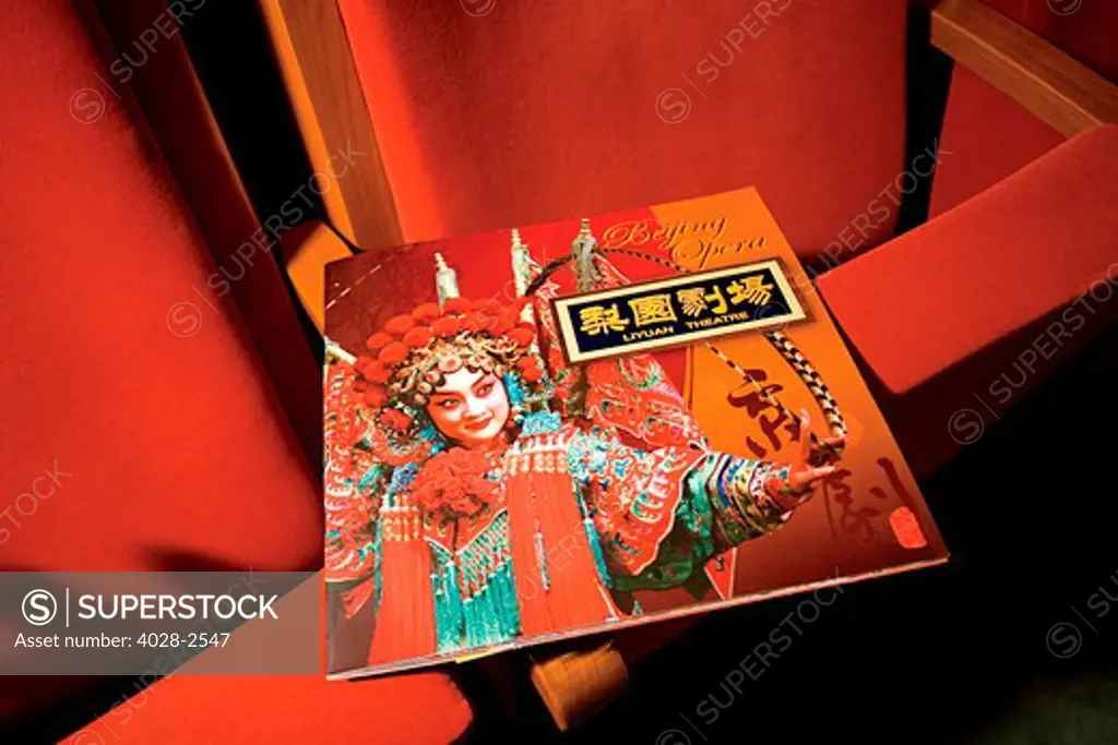 China, Beijing, Liyuan Theater, A performance program for the Beijing (Peking) Opera rests on red theater seats.