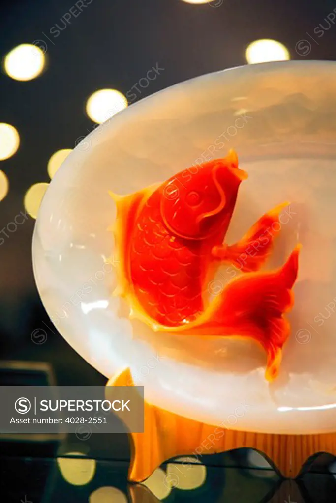 China, Xi'an, A goldfish made of rare orange jade decorates a plate at a Jade Factory.