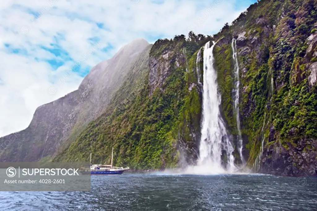 Milford Sound, Fiordland National Park, New Zealand, Sterling Falls drops 151m into the Sound as a cruise ship is sprayed with the mist