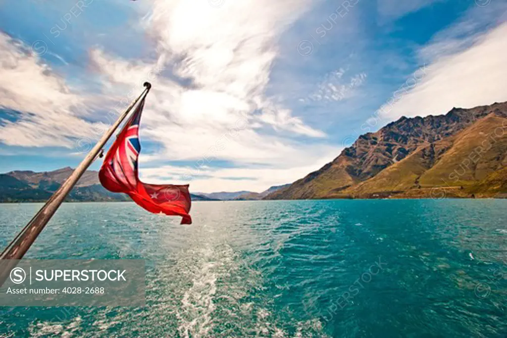 View of Lake Wakatipu on the South Island near Queenstown, New Zealand from the deck of the TSS Earnslaw framed by the New Zealand flag