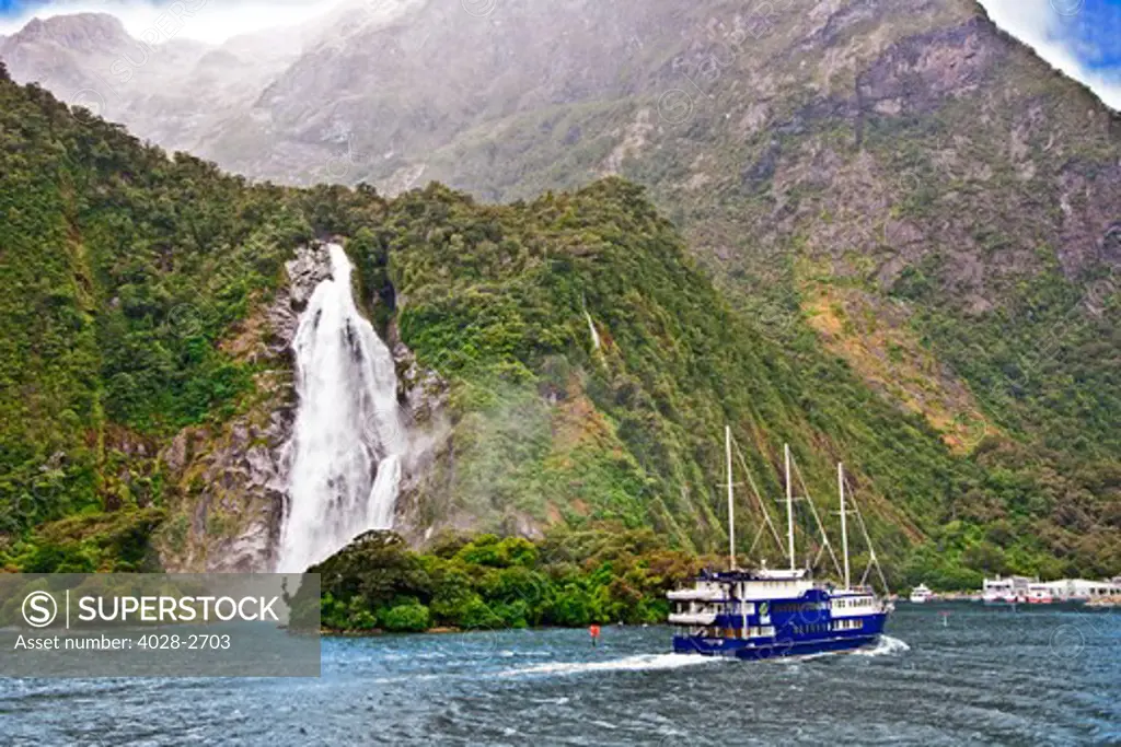 Milford Sound, Fiordland National Park, New Zealand, a  cruise ship passes Sterling Falls as it drops 151m into the Sound in Fjordland National Park