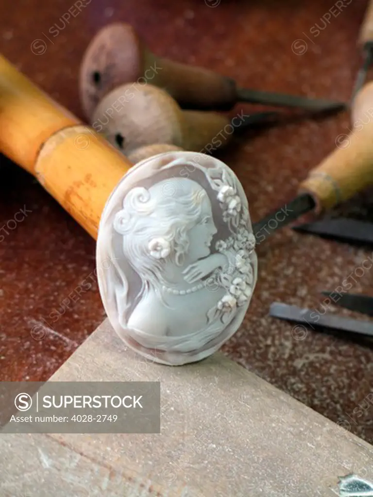 Naples, Italy, an artisan creates a finely carved cameo pendant from sea shell