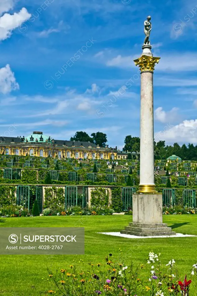 Germany, Brandenburg, Preussen, Potsdam, A column with the statue of a bathing Venus de Medici flowers next to the terraced gardens in front of main facade of Sans Souci Palace.