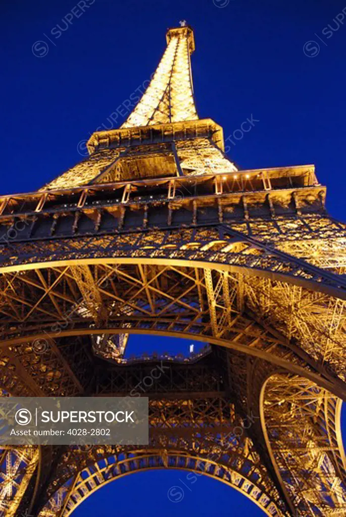 France, Paris, The Eiffel Tower (La Tour Eiffel) illuminated at night as viewed from below the structure standing 324 metres (1,063 ft) tall, 81 floors.