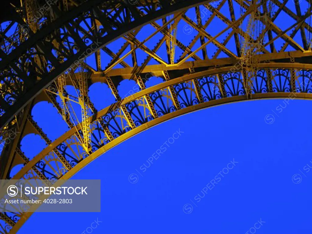 France, Paris, Detail of an archway underneath The Eiffel Tower (La Tour Eiffel) illuminated at night