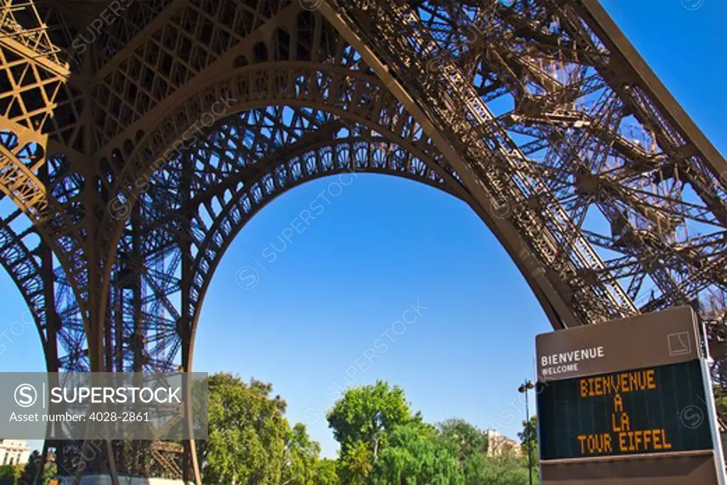 France, Paris, Detail of an Eiffel Tower (La Tour Eiffel) from underneath the base with a sign welcoming visotrs to the structure