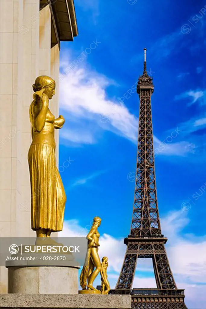 Paris, ile-de-France, France, Golden sculptures on the terrace of Palais de Chaillot with the Eiffel Tower (Tour Eiffel) in the background