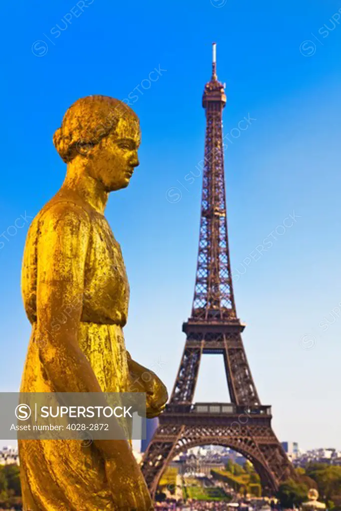Paris, ile-de-France, France, Golden sculptures on the terrace of Palais de Chaillot with the Eiffel Tower (Tour Eiffel) in the background