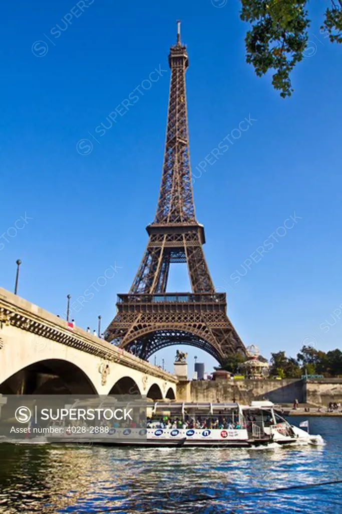 Paris, ile-de-France, France, a tourist sight seeing boat passes underneath the Pont D'Lena bridge on the Seine River by the Eiffel Tower (Tour Eiffel)
