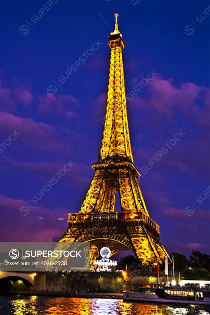 Paris, ile-de-France, France, the illuminated Eiffel Tower (Tour Eiffel) with the Pont D'Lena bridge over the Seine River at night