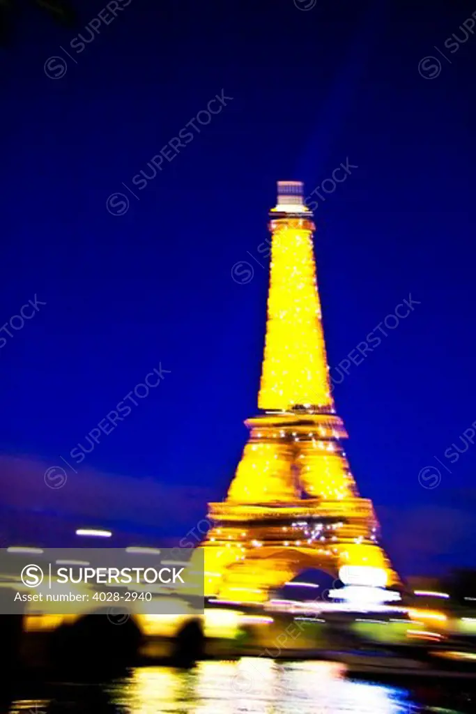 Paris, ile-de-France, France, the illuminated Eiffel Tower (Tour Eiffel) with the Pont D'Lena bridge over the Seine River shot with motion blur at night