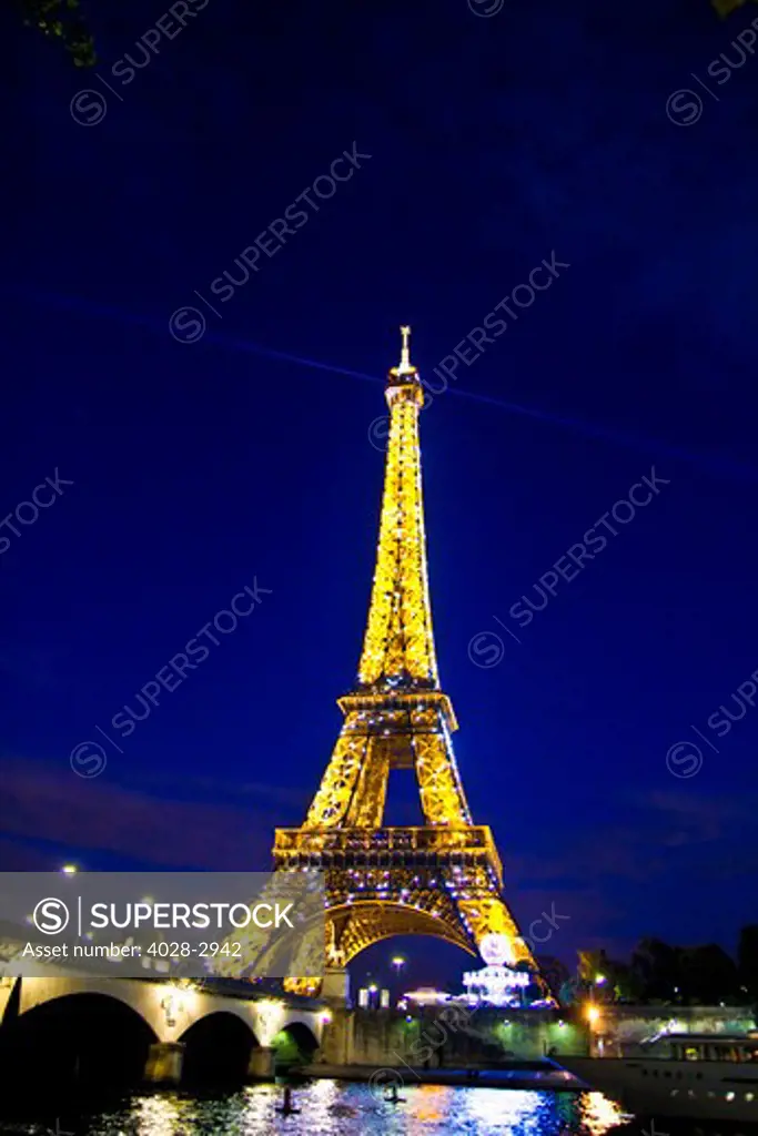 Paris, ile-de-France, France, the illuminated Eiffel Tower (Tour Eiffel) with the Pont D'Lena bridge over the Seine River at night