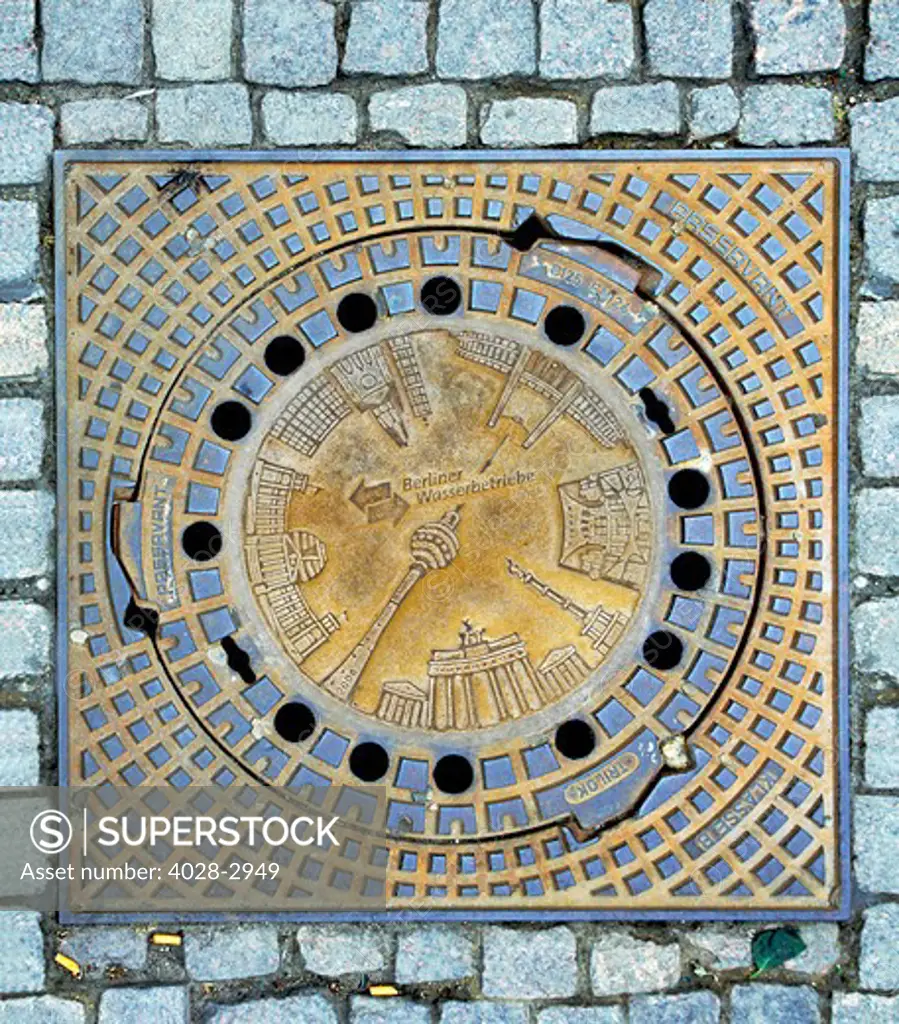 Berlin, Germany, Europe, Manhole cover with Berlin's famous sights Brandenburg Gate, Victory Column, Olympic Stadium, Televison Tower, Reichstag Parliament building