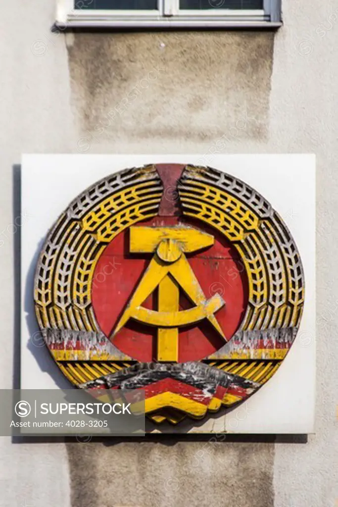 Berlin, Germany, formerly on a section of the Berlin Wall with the seal of the combined German Democratic Republic (GDR, Deutsche Demokratische Republik), and the Soviet Union, near Checkpoint Charlie