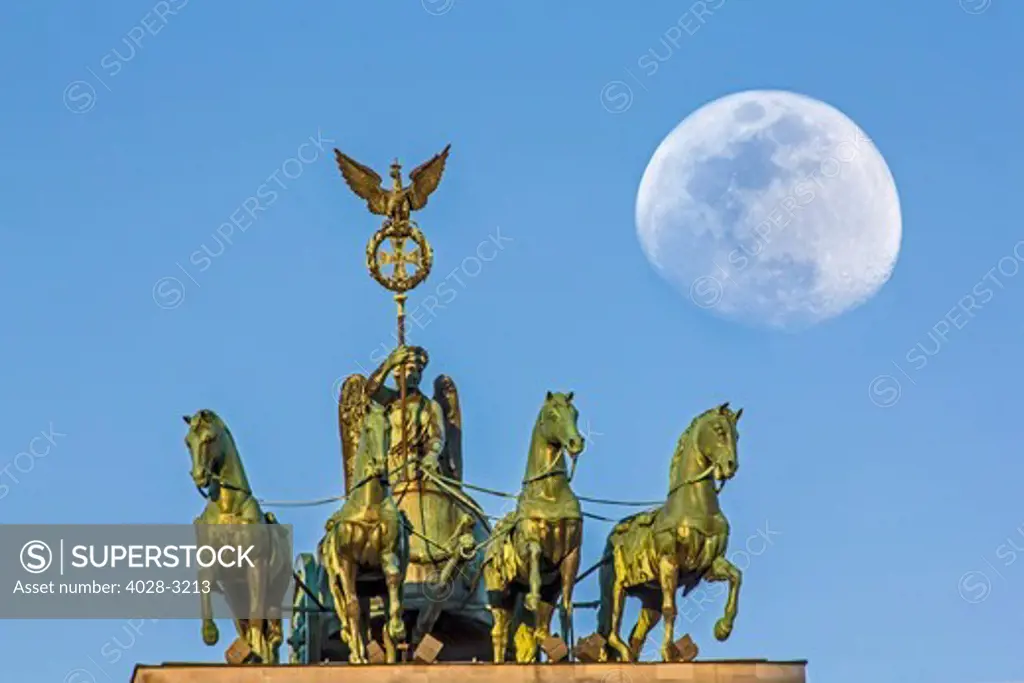 Berlin, Germany, Close-up of the Quadriga atop the Brandenburg Gate (Brandenburger Tor) with the full moon (Super Moon).
