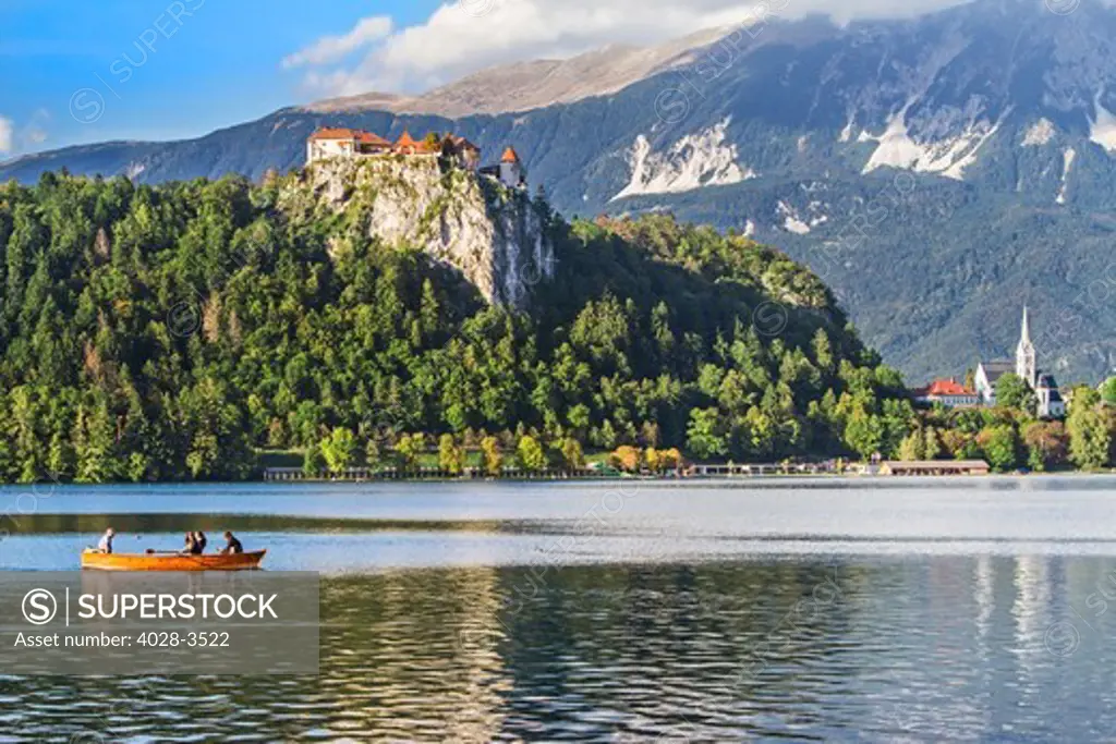 Traditional wooden pletnja rowing boat to ferry tourists to St. Mary's Church of Assumption on the island beyond, Lake Bled, Slovenia