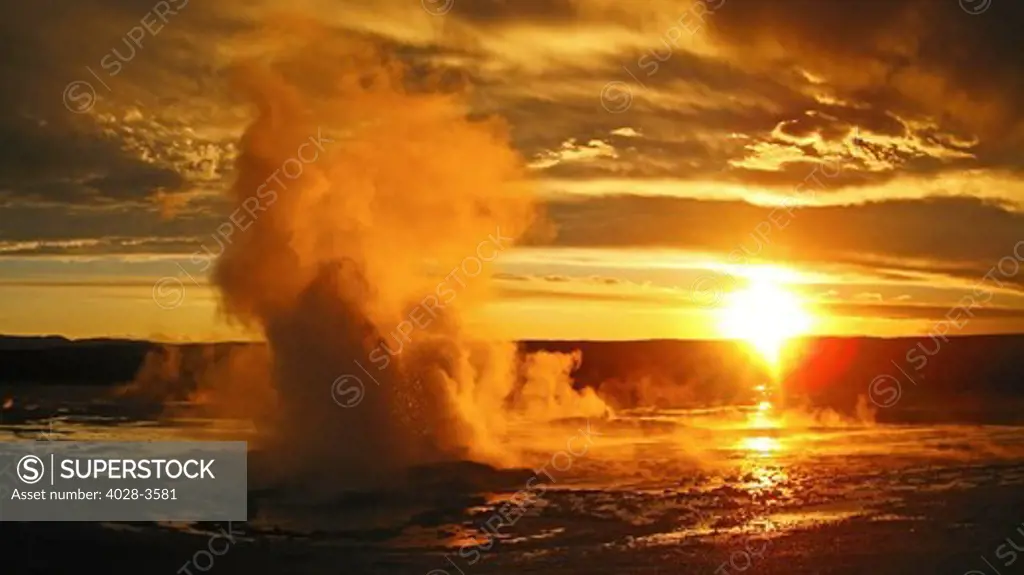 USA, Wyoming, Yellowstone National Park, Norris Geyser Basin, Whirligig geyser goes off in the Porcelin Basin as the sun sets