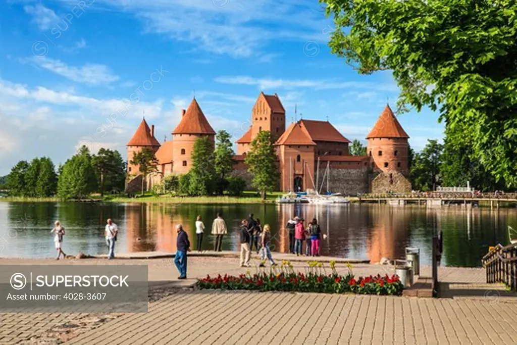 Lithuania, Vlinius, tourists admire Trakai castle reflected in Galve lake