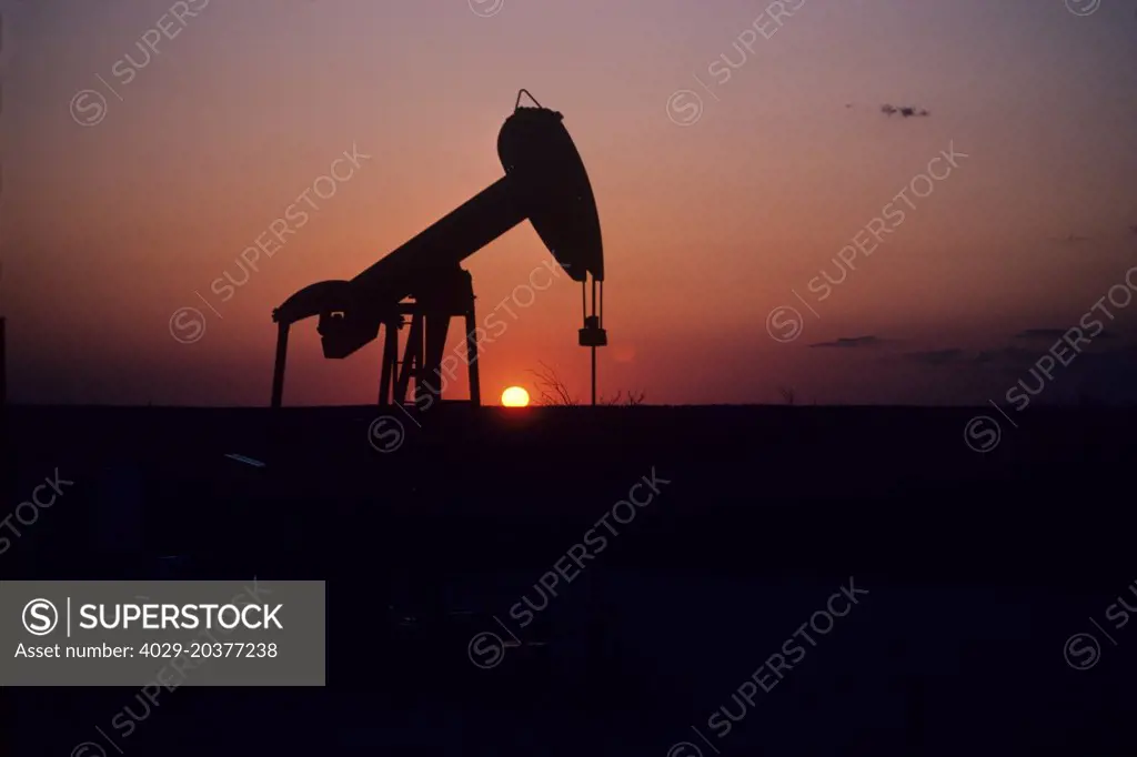 Silhouette of Pump Jack Operating at Sunset
