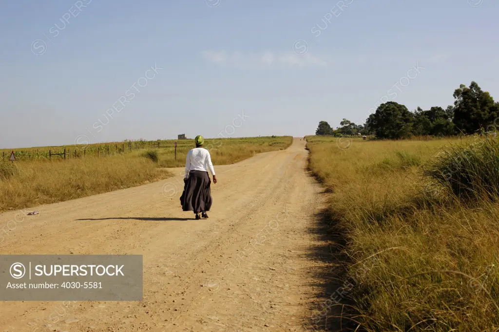 Woman walking on dirt road, Transkei