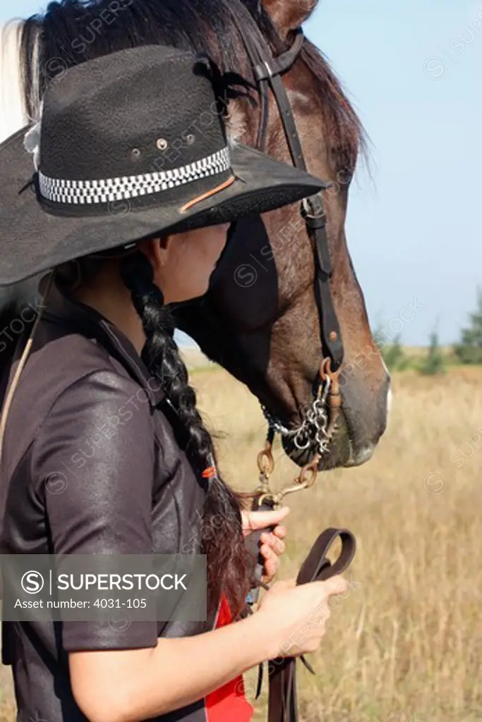 Woman horse trainer standing with her horse
