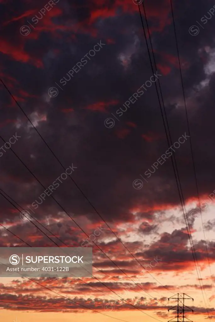 Transmission towers silhouetted against a dramatic sunset sky. Stanislaus county, California, USA