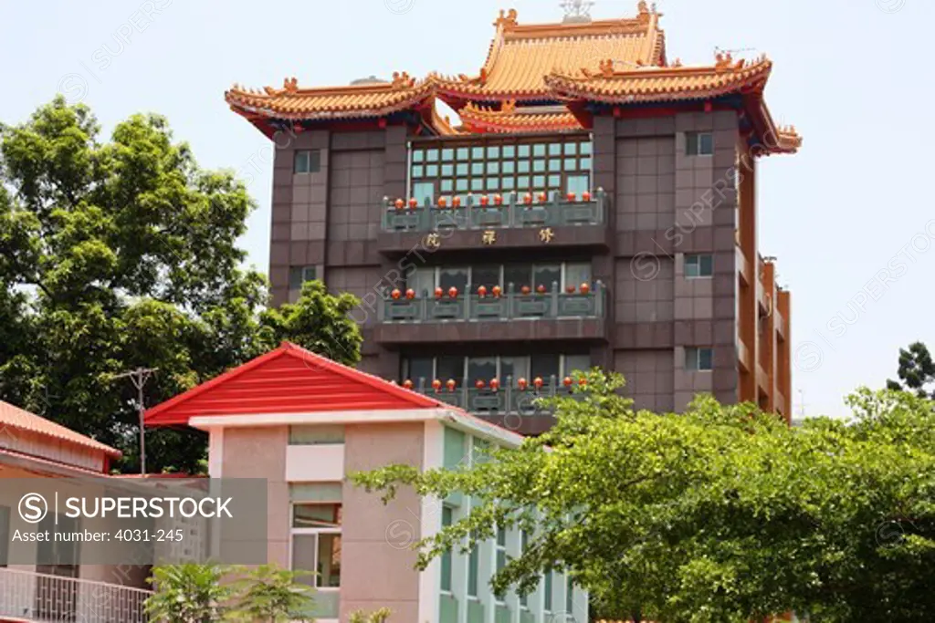 Buddhist temple with a monastery behind a modern building, Tainan, Taiwan