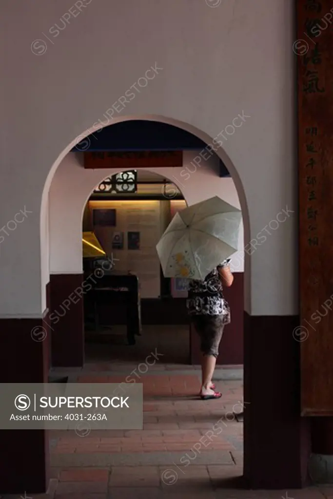Woman holding an umbrella and walking in a shrine, Koxinga Ancestral Shrine, Tainan, Taiwan