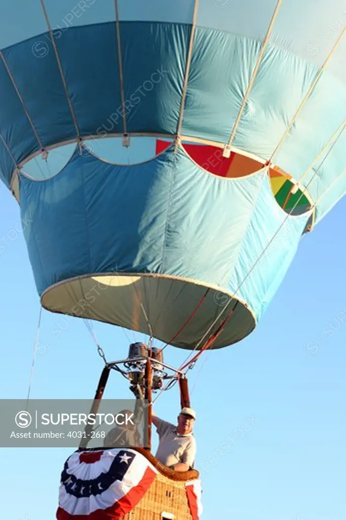 USA, California, Ripon, Pilot and passenger in gondola of hot air balloon at Color the Skies Hot Air Balloon Festival