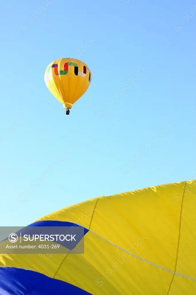 USA, California, Ripon, Hot air balloon flying over inflating balloon at Color the Skies Hot Air Balloon Festival
